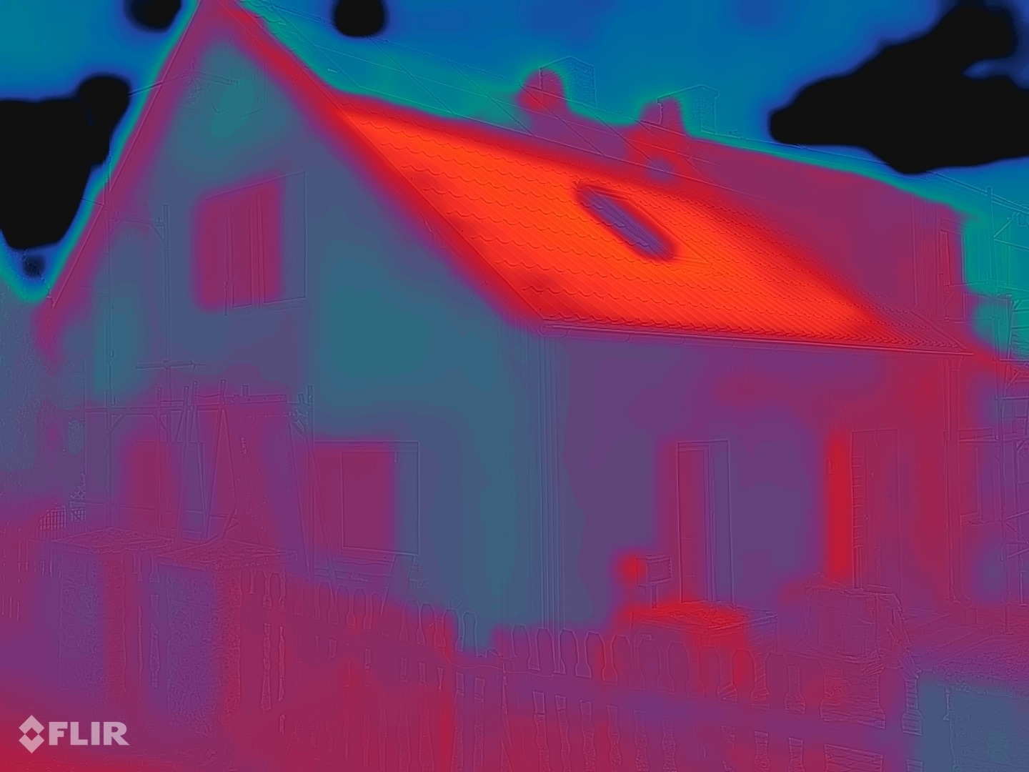Termogram FLIR i së njëjtës fasadë pas veshjes: sipërfaqja e murit nga blu-jeshile në vjollcë